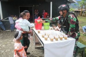 Peduli Kesehatan, Satgas Yonif 303/SSM Kostrad Bagikan Bubur Kacang Hijau kepada Masyarakat dan Anak-anak di Desa Binaan