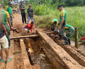 Satgas Pamtas Yonarmed 10 Kostrad Bantu Warga Perbatasan Perbaiki Jembatan